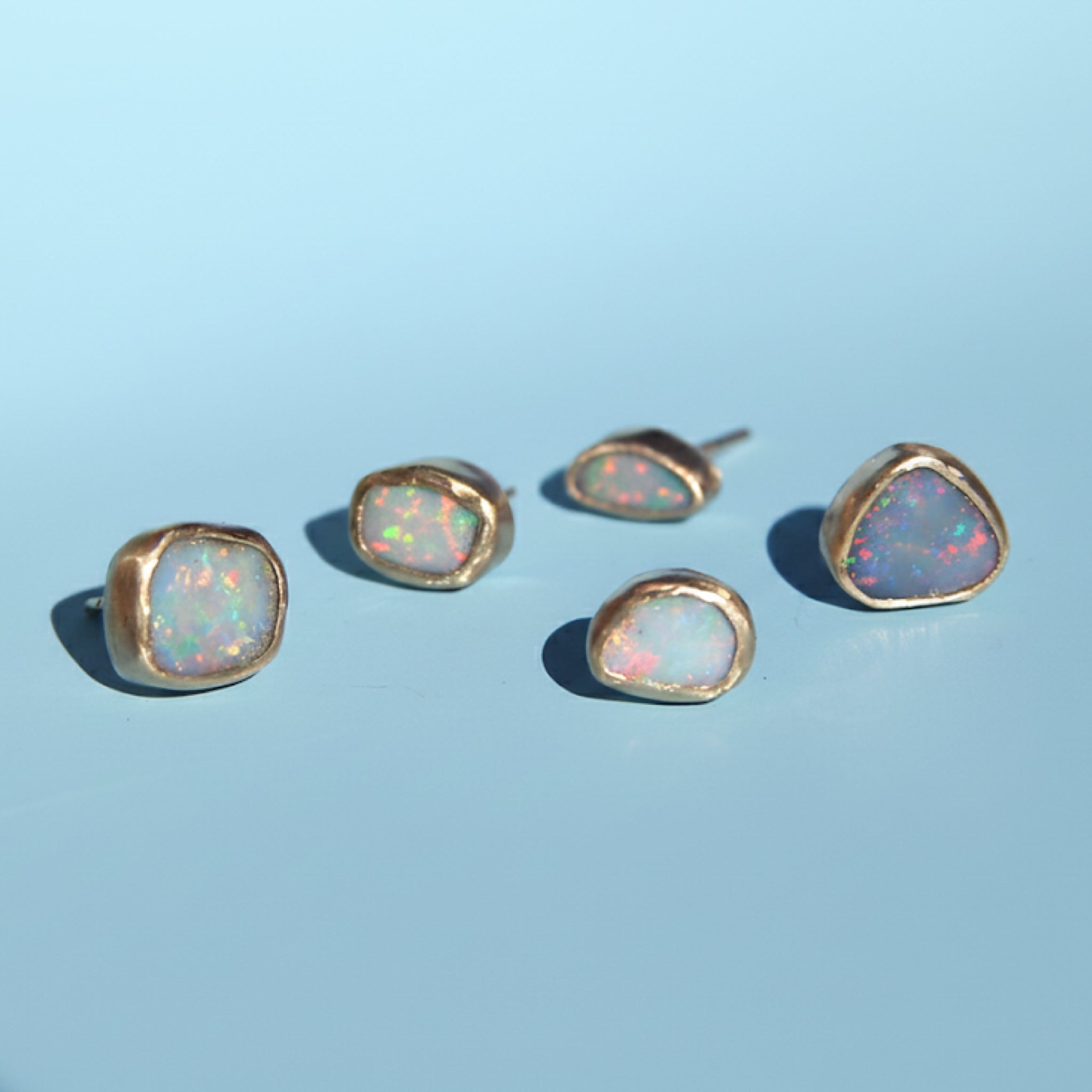 Asymmetrical oval opal studs in gold